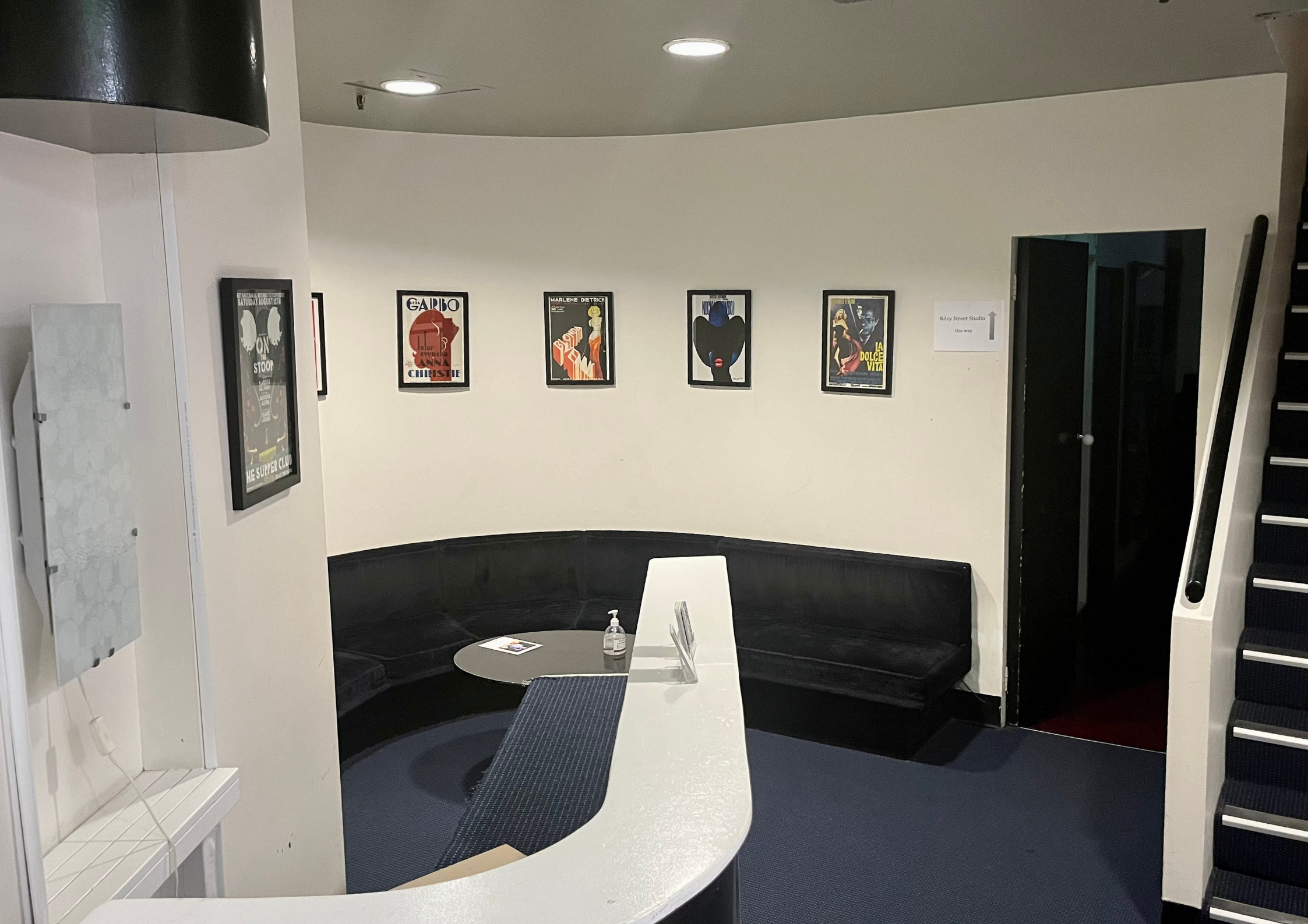 Reception and lounge area with curved seating and studio artwork.