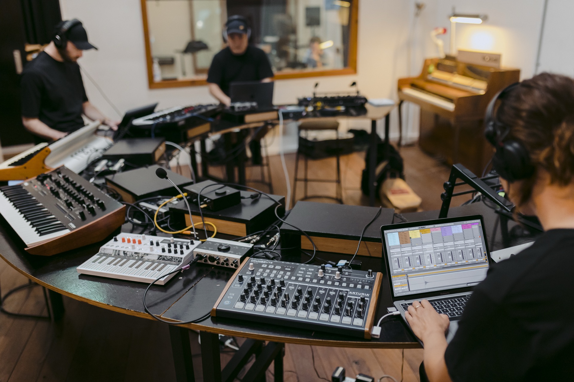 students sampling drum machines and synthesisers in a recording studio classroom