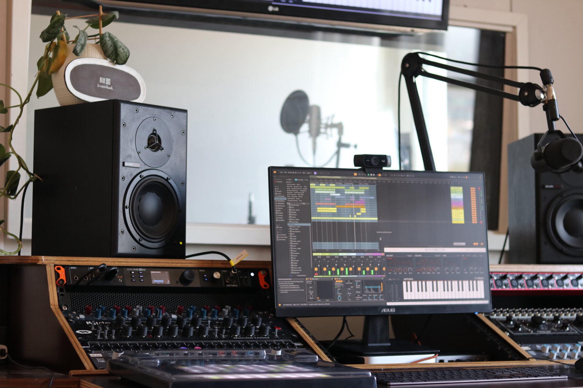 Production studio with vocal booth, microphones and outboard audio hardware integrated with Ableton Live