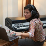 student in a music studio recording a rhodes keyboard into ableton live.