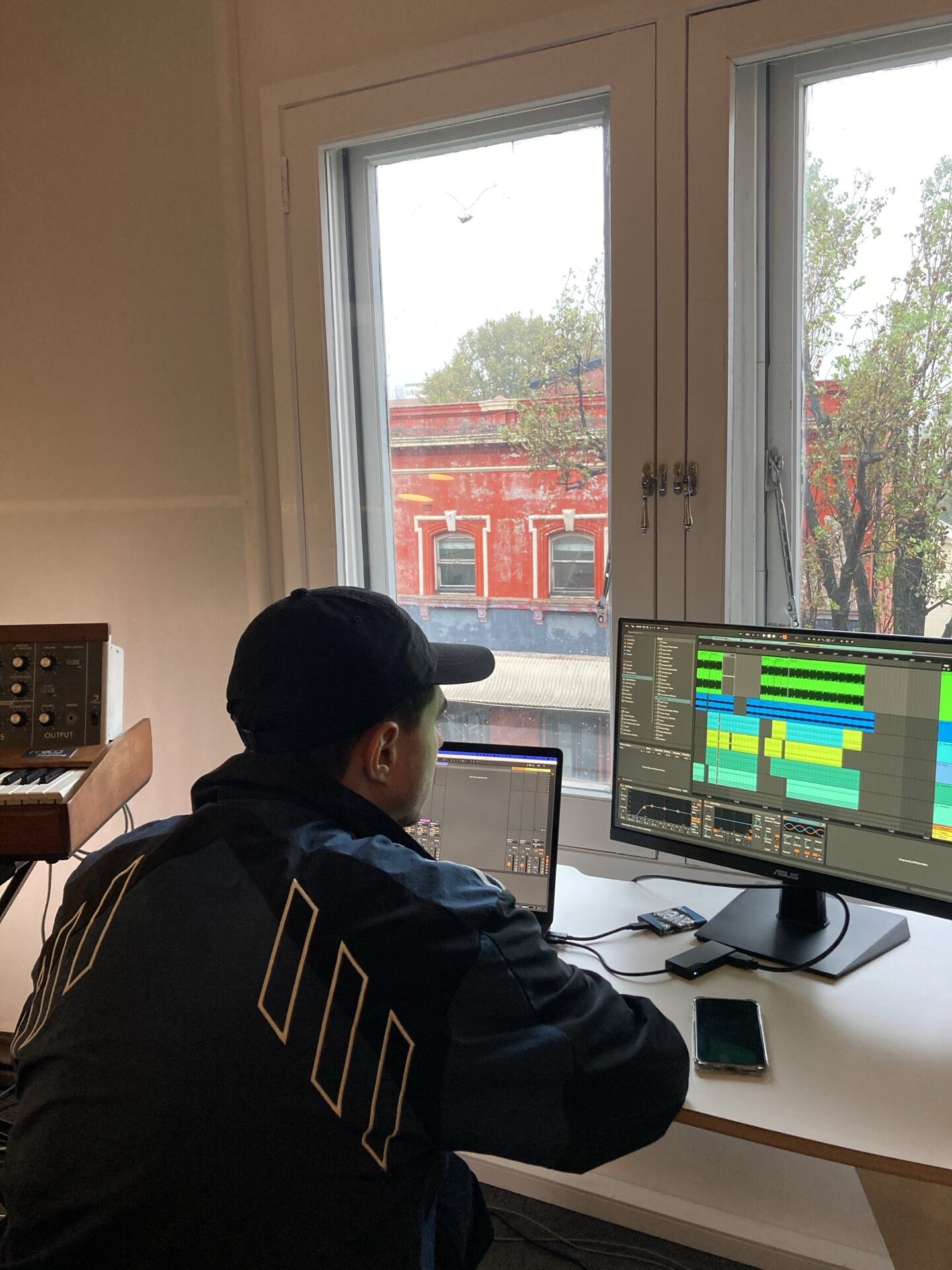 producer making music at Liveschool Sydney with Ableton Live on a laptop, 2nd display and Minimoog Model D.