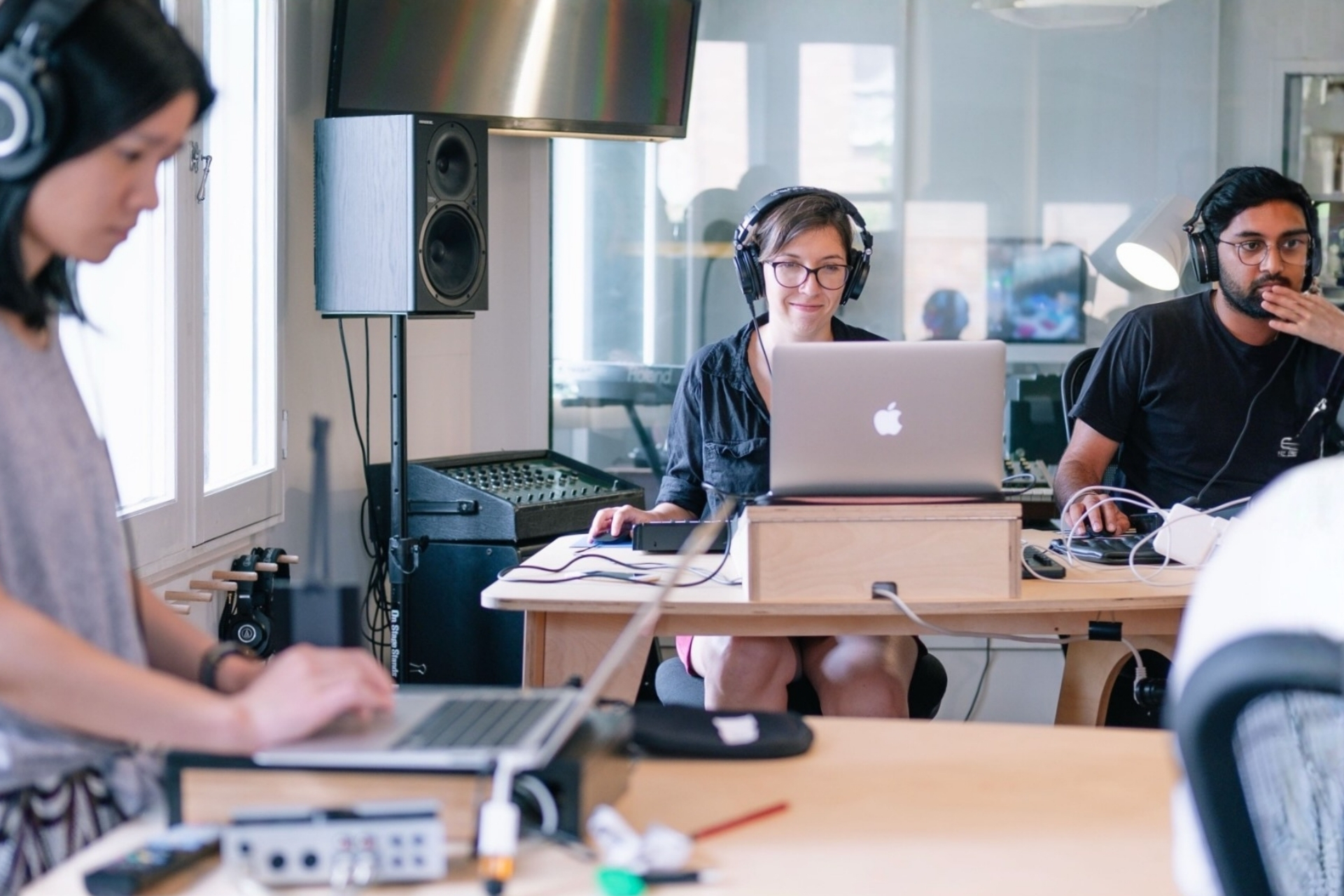 students with headphones on making music in a production class with Ableton Live in a bright sunny studio